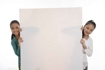 happy two young girl holding empty white boardの写真素材