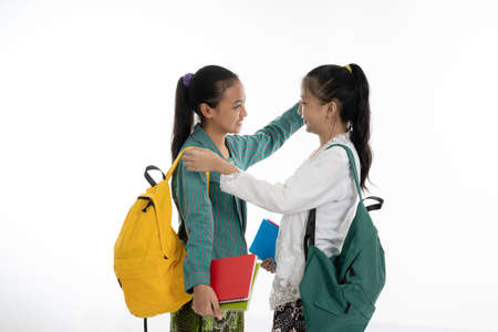 two couple student meet friend carrying bag and books in traditional clothesの写真素材