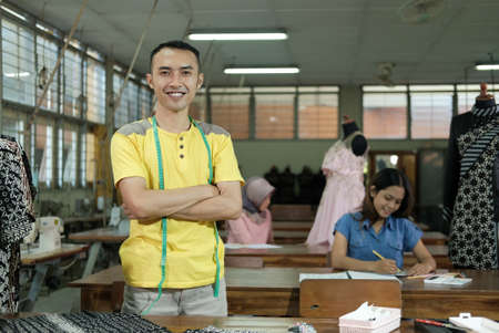 smile tailor man standing with crossed handsの写真素材