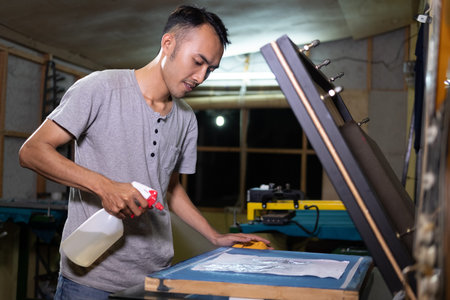 Male worker using sprayer to to paste the paper when going to make a film