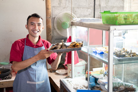 smiling male waiters carrying trays of side dishes near the display windows
