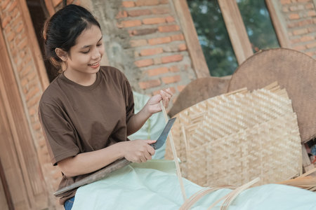 Asian women use knives to make bamboo slats