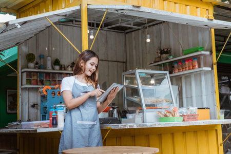 woman taking online order at her small stall shop