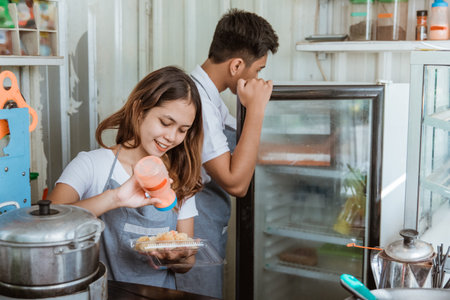 portrait a young man and woman prepare food and beverage