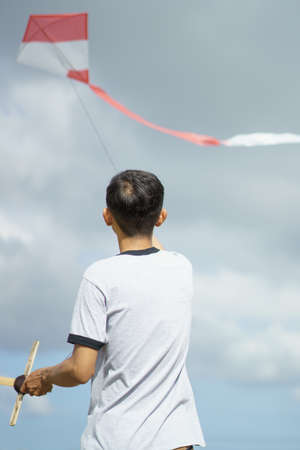 portrait of a young man playing a kiteの写真素材