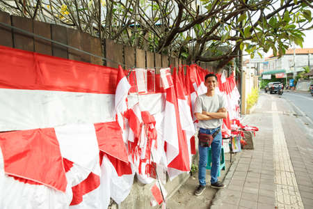 portrait of a young man selling flagsの写真素材
