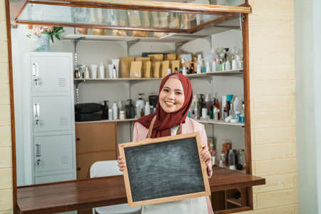 portrait young muslim woman selling packaged productsの写真素材