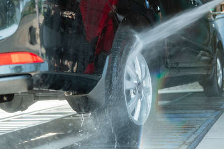 Car cleaners that use high-pressure water sprayers use a hose to the tiresの写真素材
