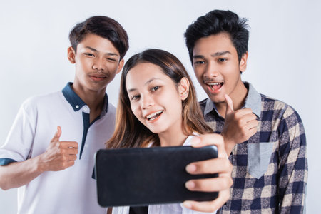 Portrait of happy university youth carrying a bag and taking a selfie with the cellphone