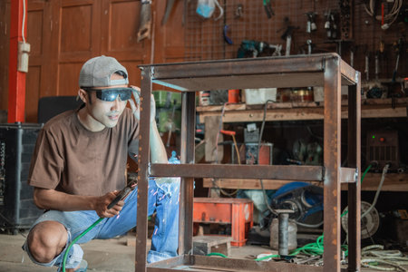 Squat welder prepares the equipment to make iron racks