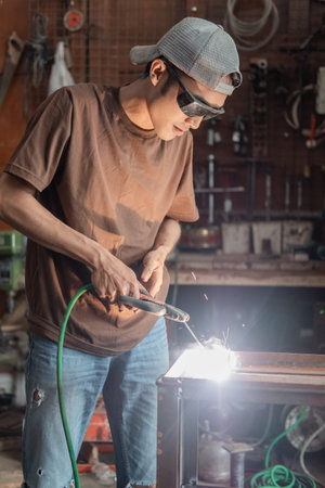 Welders stand up wearing black welding glasses when making metal racksの写真素材