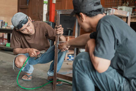 customer shows with finger pointing of part to be welded to welderの写真素材