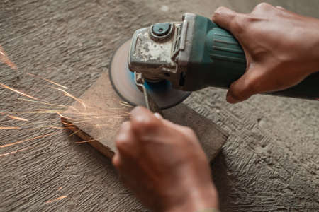 close up of welders hand using a grinder to cut ironの写真素材