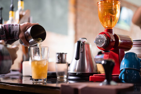 barista pouring drink into glass.