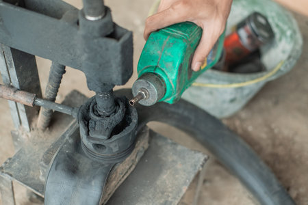 close up of tire repairmans hand when pouring fuel on a traditional press