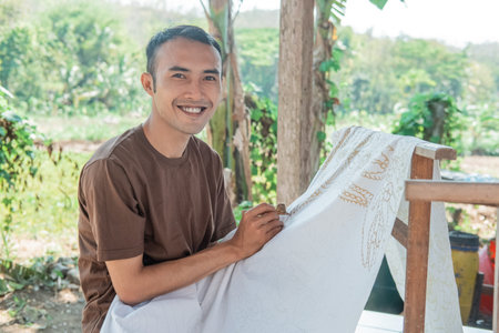 portrait of a man drawing batik
