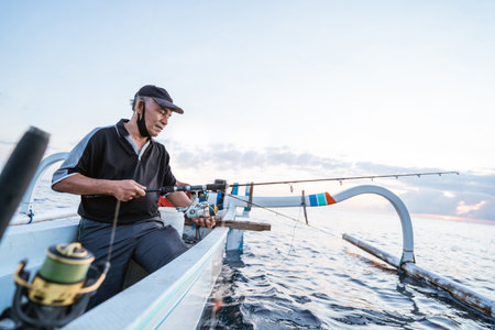 Portrait of a young fisherman fishing on a boatの写真素材