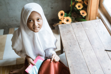 indonesian school student preparing her book at home before going to schoolの写真素材