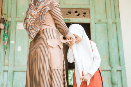 muslim student shake and kiss her mother hand before going to the schoolの写真素材