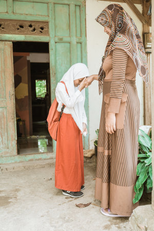 muslim student shake and kiss her mother hand before going to the schoolの写真素材