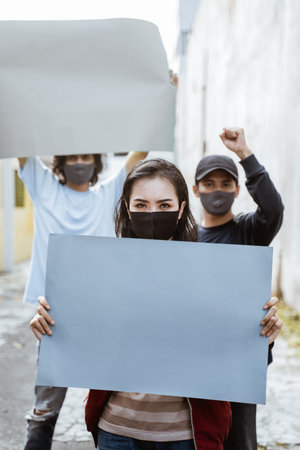 Portrait students holding blank paper conducting demonstrations