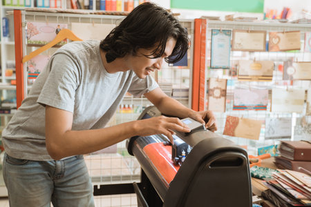 Young male entrepreneur Making sticker paper by machine