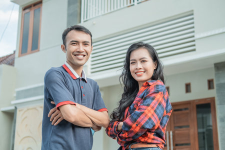 asian male and female with crossed hands standsの写真素材