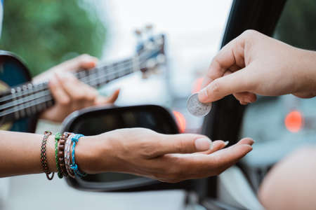 close up of busker hand receiving coin given by someoneの写真素材