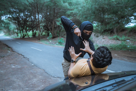 man in a car is robbed by a criminal with a knifeの写真素材