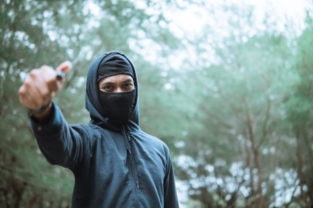 thief in a mask pointed the knife at the camera beside copyspaceの写真素材