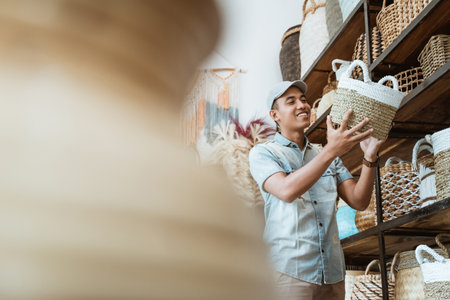 Asian man in hat holding a woven bagの写真素材