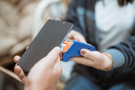 close up of handphone near Electronic Data Capture machineの写真素材