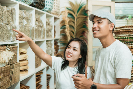 young Asian couple searches for and selects the handicraft products they want to buyの写真素材
