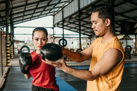 Trainer with a woman boxer during a trainingの写真素材