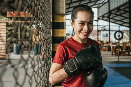 smiling woman ultimate fighter in boxing gloves standing