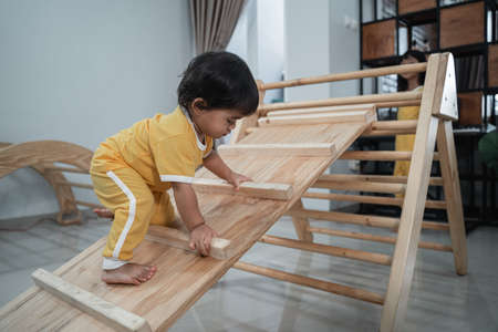 Little Asian Baby Crawling Ride On Pikler Triangle Toysの写真素材