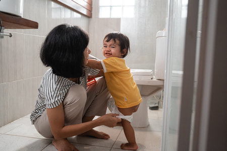 a mother puts her babys diaper on after poopingの写真素材