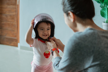 cute little baby wearing a helmet with his mother