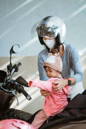 a little baby wearing a jacket with his motherの写真素材