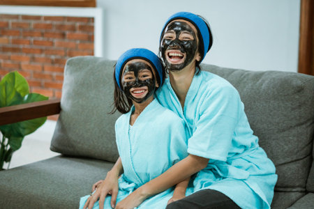 Having fun mother and daughter using facial clay masks together