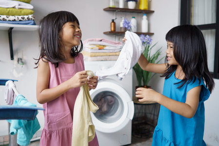 two children having fun doing laundry