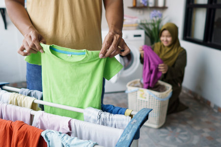 muslim woman and her husband doing laundry togetherの写真素材