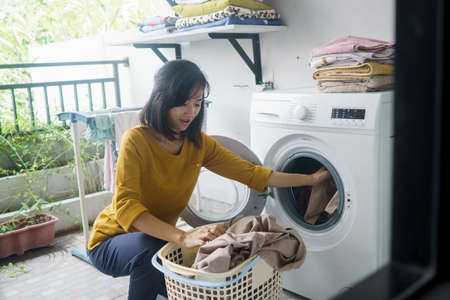 woman in front of the washing machineの写真素材