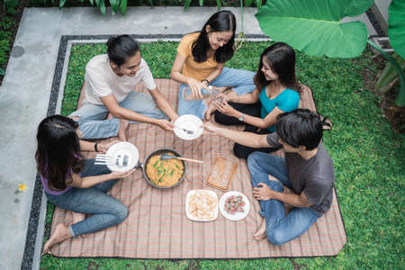 friends having fun while eating and drinking in the backyard - Happy people togetherの写真素材