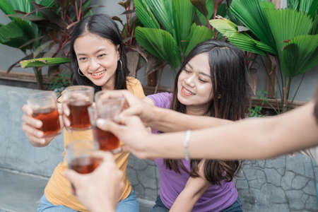 friends having fun while eating and drinking in the backyard - Happy people at garden partyの写真素材