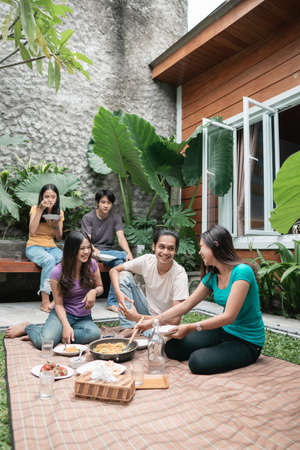 friends having fun while eating and drinking in the backyard - Happy people at garden partyの写真素材