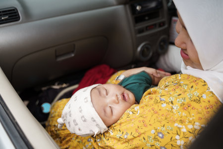 baby boy with her muslim mom inside car going for a tripの写真素材