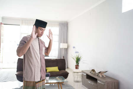 Young Muslim man praying at homeの写真素材