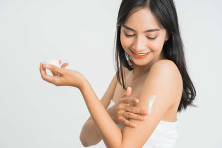 skin care woman applying body lotion on arm and shoulderの写真素材