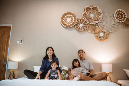 family with two children spend their time together in the bedroomの写真素材